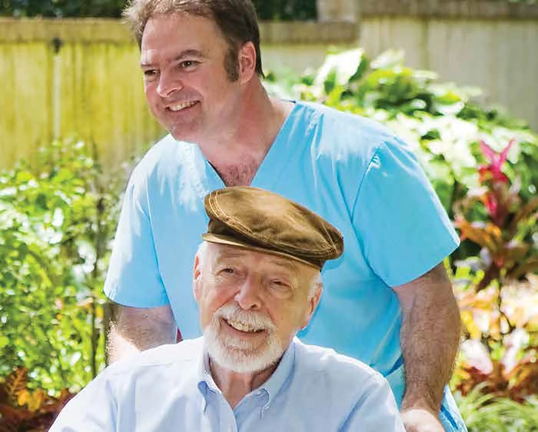 A caregiver with an older man in a garden